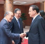 握手する李首相(右)と三村会頭
