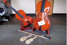 本物に比べてミニサイズのバイオリンの置き物（左）。その前にあるのは、廃材を使って製作した土産物の試作品だ