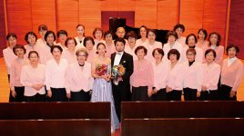 チャリティーコンサートの後、テノール歌手の小堀勇介氏とピアニストの久保山菜摘氏に花束を渡す女性会の皆さん