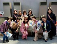鹿の角のモチーフを着けて来場者にPRする女性会メンバー