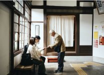 青梅線鳩ノ巣駅に設置されたフロントで“無人駅チェックイン”した宿泊客を迎える地元の人