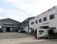 大型機械が並ぶ工場と社屋外観