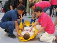 講師や女性会メンバーが担架搬送を実演