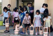 「打ち水」で暑さを和らげる子どもたち