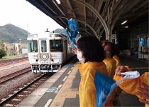 旗を振って観光客をお見送り