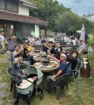 牧場に隣接する古民家ゲストハウスの庭で、ビールとジンギスカンを楽しむ人々