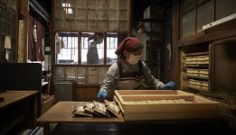 二軒茶屋餅は人の手で丁寧に竹皮で包んでいく
